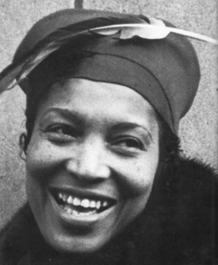 Picture of Zora with feather in cap and grin going from ear to ear
